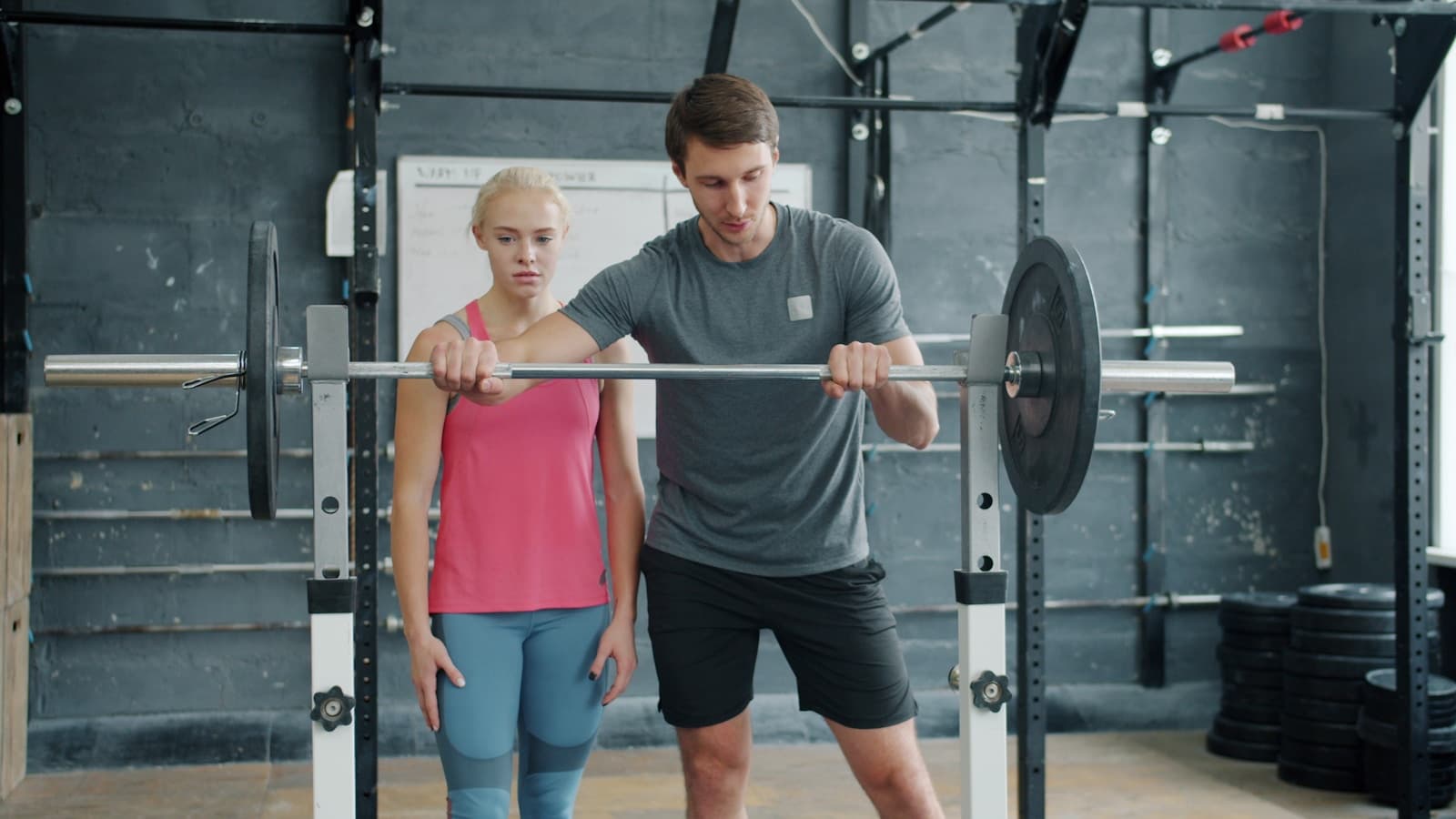 An athlete receiving focused barbell coaching during strength training.