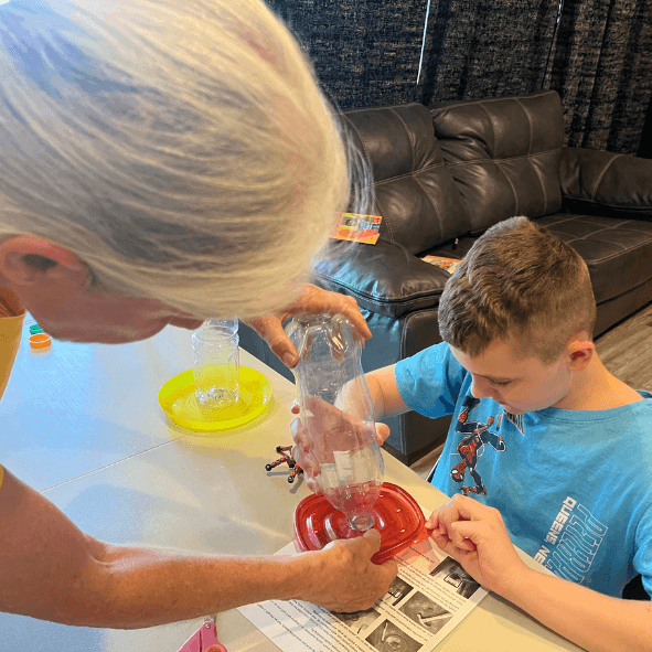 A student and teacher building a bottle science experiment at Community Schoolhouse.